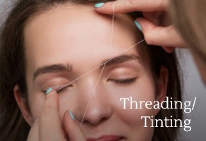 Woman getting threading and tinting done on eyebrows